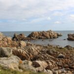Zasmušilý pohled na snadno dostupné severní pobřeží ostrova Guernsey s obnaženým žulovým podložím